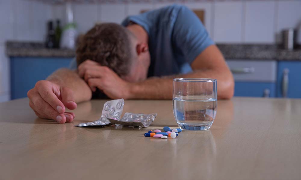 A distressed man after having medication rests on his head