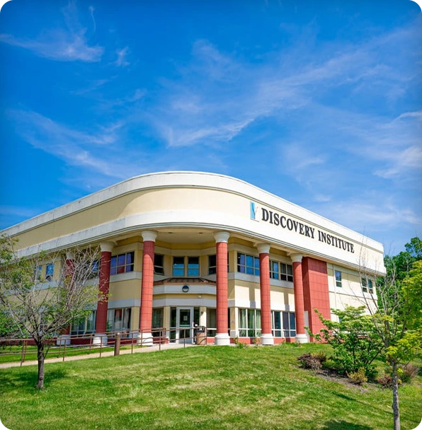 Image75 Discovery Institute building with red columns, beige walls, and logo sign.