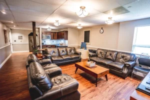 DSC00768-117-Recovered Living room with brown leather sofas, wooden floor, coffee table, and ceiling lights.