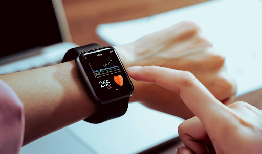 unnamed (1) Person wearing a smartwatch with health data, touching the screen.